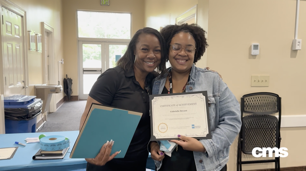  Department director hugs student wellness support staff during recognition luncheon